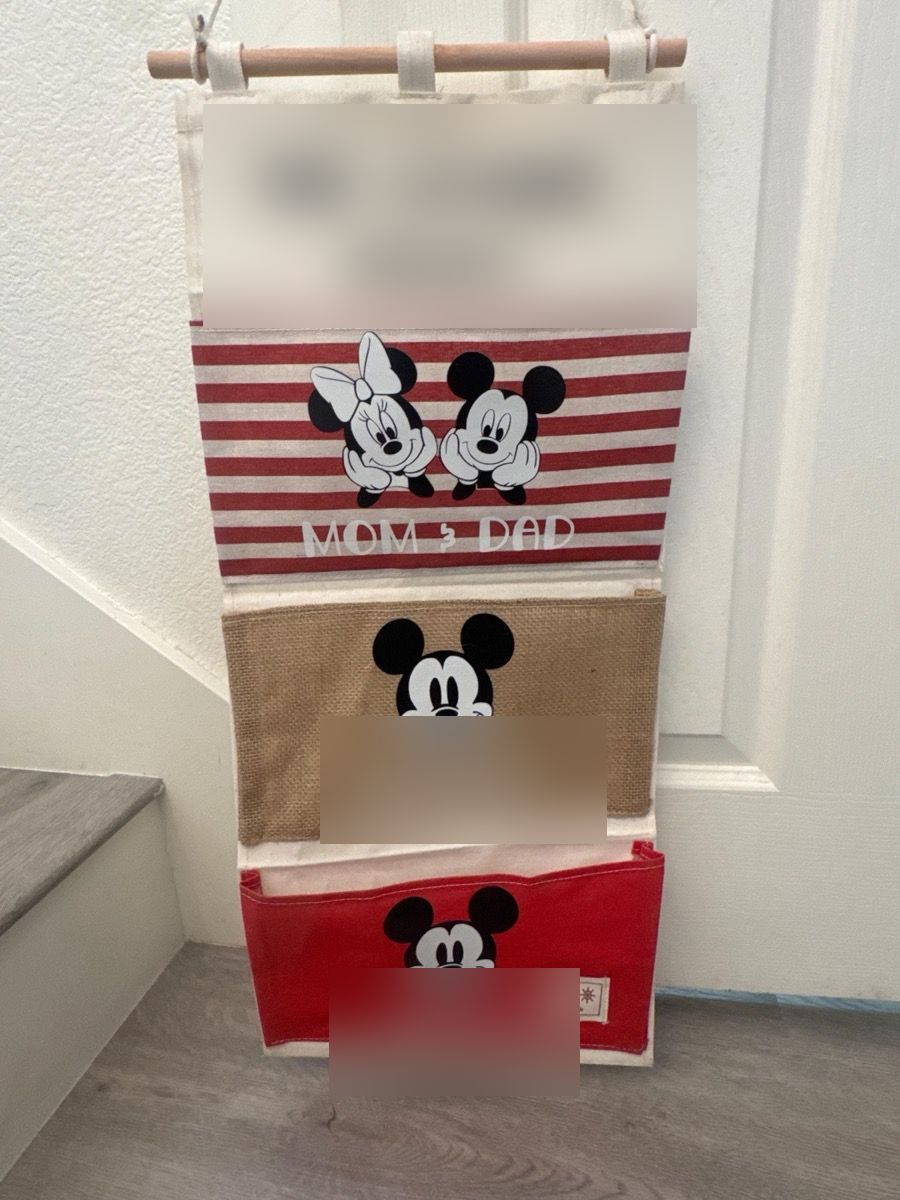 A red-stripe fish extender reading Mom & Dad, with Mickey on the burlap and red pockets